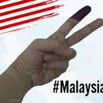 Ink dipped finger, indicating the person has voted, holds up a peace sign with a Malaysian flag in the top left corner, and the #MalaysiaMemilih in the lower right section.