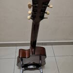 DIY guitar stand with a guitar mounted on it, viewed from behind, and slightly elevated,