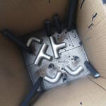 PVC elbow and T joints being painted in a box.