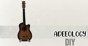 An image with the words D.I.Y and a guitar, set up on a DIY stand made from PVC pipes.