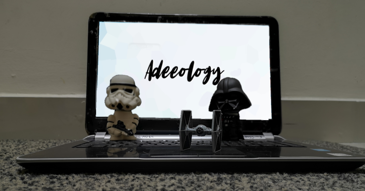 Picture of Adee's laptop, with Darth Vader and a Stormtrooper figurines flanking a Tie Fighter figurine on the keyboard.